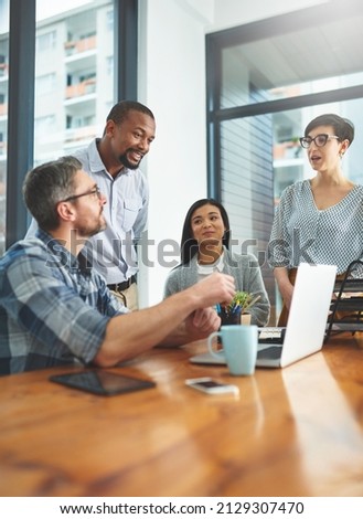 Working together to get the task done. Shot of businesspeople working together in the office.
