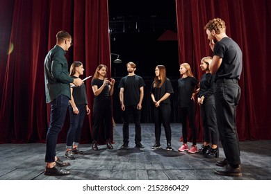 Working together. Group of actors in dark colored clothes on rehearsal in the theater. - Powered by Shutterstock