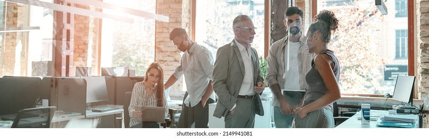 Working together. Group of modern people communicating and discussing fresh ideas while standing in the creative office - Shutterstock ID 2149941081
