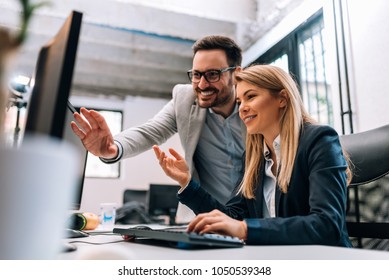 Working together on project. Two young business colleagues working on computer - Shutterstock ID 1050539348