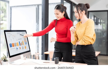 Working together on project. Two young business colleagues working on computer