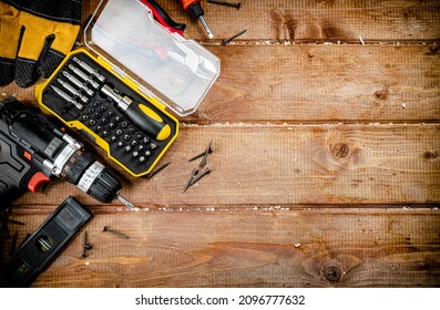 Working tool. Screwdriver with self-tapping screws on the table. On a wooden background. High quality photo