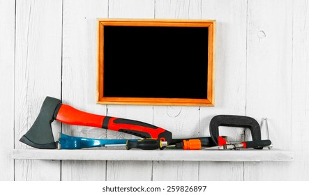 Working tools and frame. On a white, wooden background.