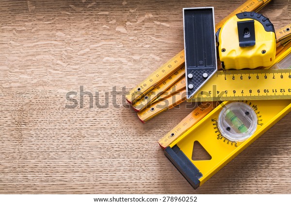 Working tools of measurement on oaken wooden board\
construction concept 
