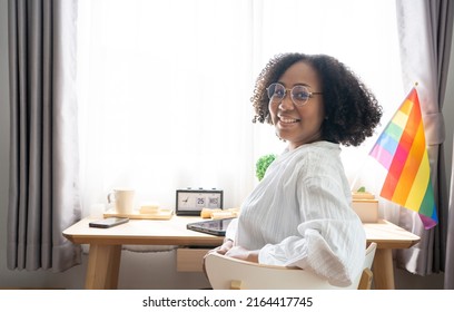 Working Woman LGBTQ+ Afro Hair Style African American Lesbian, Beautiful Gay Working On Tablet With Love Moment Spending Good Time Together, Lgbt Rainbow, Pride Flag On Table Near Curtain At Window.