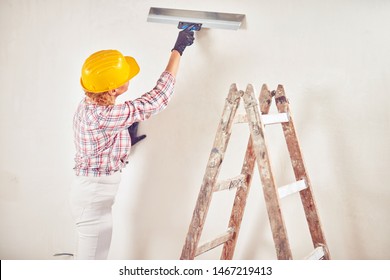 Working Woman Plastering / Painting Walls Inside The House.