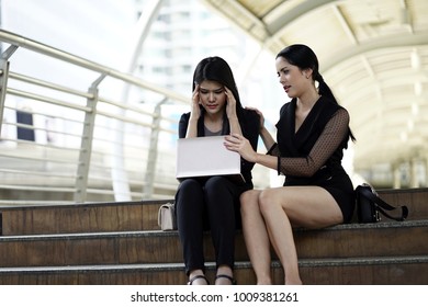 Working Woman Sitting With Friend On The Stair Case . Empathy Concept. The Woman Hand Touch Friend Shoulder For Empathy.The Working Woman Worry About Work And Feeling Sick With Laptop Outdoor .