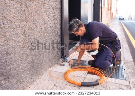 working woman.female engineer of a telecommunication company doing the installation of fiber optics in a house.telephone company worker installing fiber optics in a house.