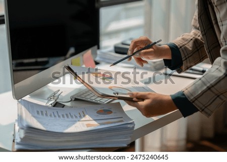 working in workplace on the desk with computer, female employee is looking on document, en entrepreneur is trying so hard to build startup company, finance department