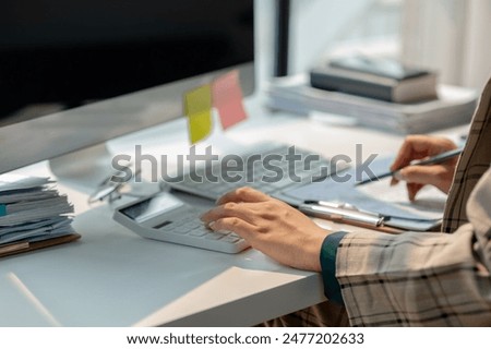 working in workplace on the desk with computer, female employee is looking on document, en entrepreneur is trying so hard to build startup company, finance department