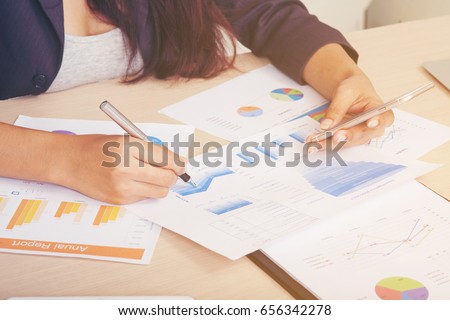 working-class woman is checking, Reshipping,  and Graphing the annual Report accurately to match the boss's submitted corrections. reliability before making a summary of the annual report.