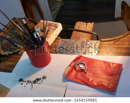 Workingplace of a jewelry designer in his workshop with tools and silver jewelry in Santiago de Compostela in Spain