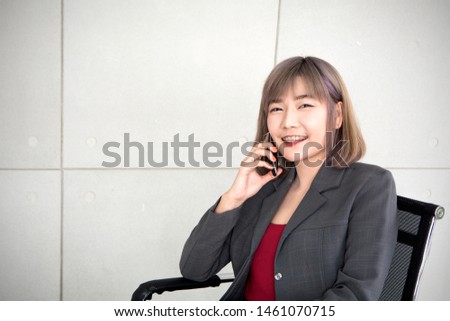 Workingwomen smiling and talking to mobile phone to welcome good news