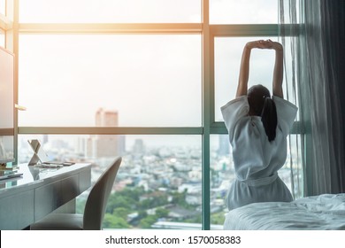 Work-life Balance City Living Quality Concept With Happy Asian Girl Lifestyle Having Good Day Morning Waking Up From Sleep  Taking Some Rest, Lazily Relaxing In Comfort Condominium Or Hotel Bed Room