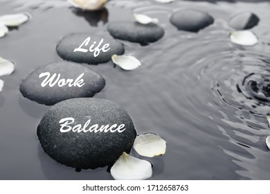 Work-life balance concept. Stones and flower petals in water - Shutterstock ID 1712658763