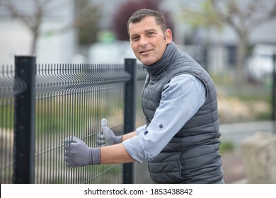 Workman Erecting A Wire Fence