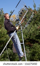 Workman Installing HDTV Digital Antenna On A House