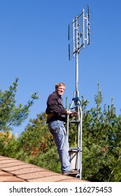 Workman Installing HDTV Digital Antenna On A House