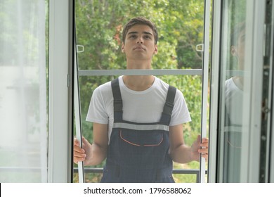 Workman Is Installing Insect Mesh Screen On Window To Protect Room From Mosquito, Fly, Insects