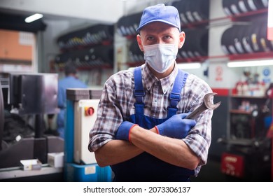 Workman In Protective Mask Standing Near Car At Auto Repair Shop