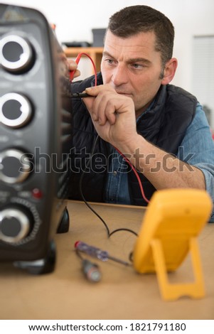 workman testing oven with a multimeter