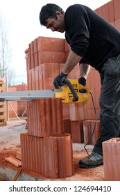 A workman using a chainsaw