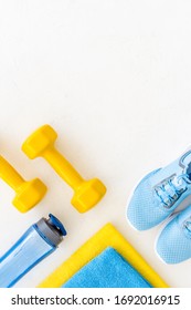 Workout Accessories. Sneakers, Dumbbells, Towel On White Background Top View Copy Space