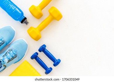 Workout Accessories. Sneakers, Dumbbells, Towel On White Background Top View Copy Space