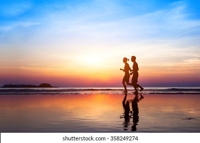 Workout Background, Two People Jogging On The Beach At Sunset, Runners Silhouettes, Healthy Lifestyle Concept 