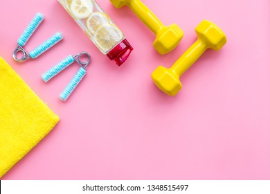 Workout With Bars, Bottle Of Water And Wrist Builder Pink Background Top View Mockup