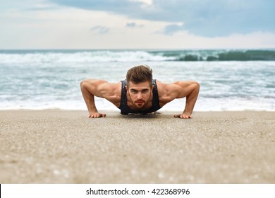 Workout Exercise. Closeup Of Healthy Handsome Active Man With Fit Muscular Body Doing Push Ups Exercises. Sporty Athletic Male Exercising At Beach, Training Outdoor. Sports And Fitness Concept