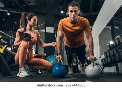 Workout, Fitness workout in gym with trainer assisted in training, Fitness concept, Fit asian woman, Young white man and asian girl exercising in the gym. - Powered by Shutterstock