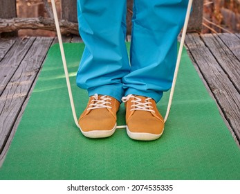 Workout With A Heavy Jump Rope - Feet On Exercise Mat, Backyard Fitness Concept