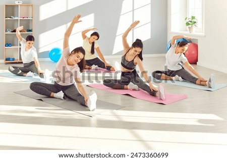 Workout training women sports team practices gymnastics and stretching exercises on exercise mat. Women sport physical activity regular workouts women healthy lifestyle stretching gymnastics