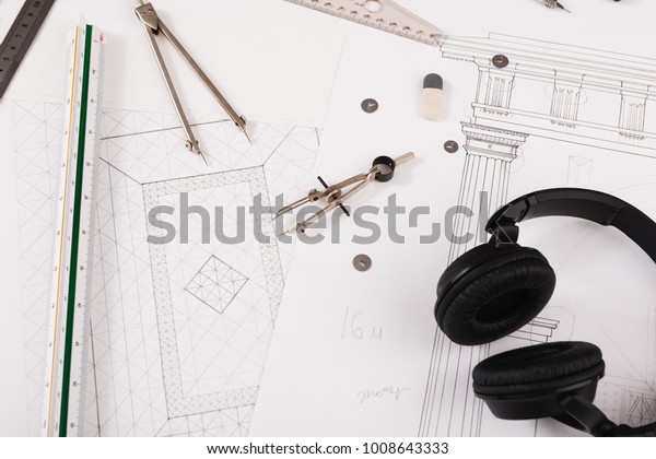 Workplace of architect. Engineering blueprint,\
headphones and divider for creating new architectural project on\
table, copy space