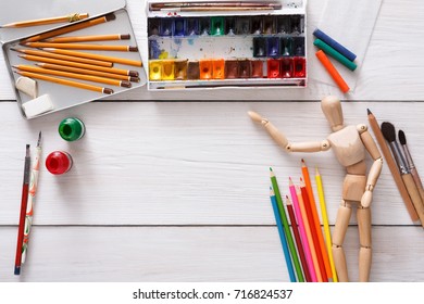 Workplace Of Artist. Paints And Wooden Painter Man With Brushes On White Desk, Top View, Flat Lay, Objects