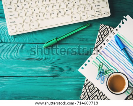Workplace background with keyboard, notebook on dark green wooden background. Online blog concept