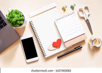 Workplace with blank notepad and smartphone on pastel background. Valentine’s day - Powered by Shutterstock