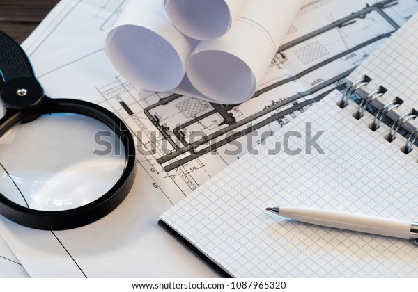 Workplace with blueprint of engineer designer\
Project notepad with copy space Energy Engineering Concept\
Technological scheme of heating house\
building