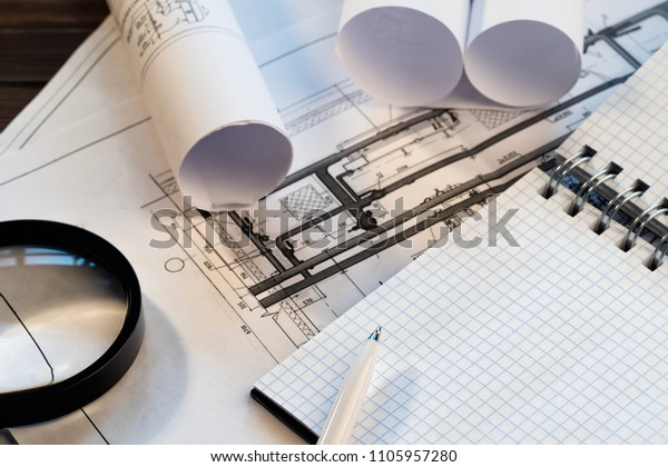 Workplace with blueprint of engineer designer\
Project notepad with copy space Energy Engineering Concept\
Technological scheme of heating house\
building