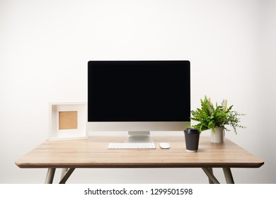 Workplace With Coffee To Go, Photo Frame, Green Plant And Desktop Computer With Copy Space Isolated On White