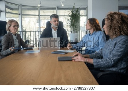 Workplace disagreement between different generations during office discussion. Professional colleagues expressing differing opinions during a team meeting.