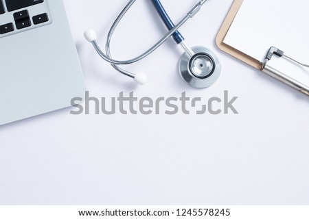 Workplace of doctor with laptop and stethoscope and notebook on white table top view shot.