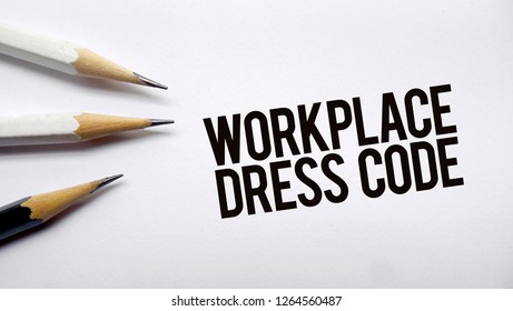 Workplace dress code text memo written on a white background with pencils