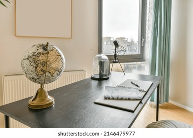 Workplace with a globe on the table next to the window and a view of the city