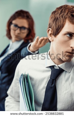 Workplace harassment is captured through subtle body language. A man under emotional pressure from a female colleague, her gesture dismissive, shows how continuous psychological abuse impacts him deep