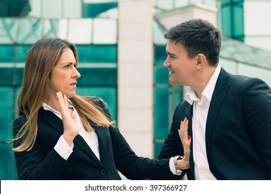 Workplace harassment - young business woman stopping aggressive colleague