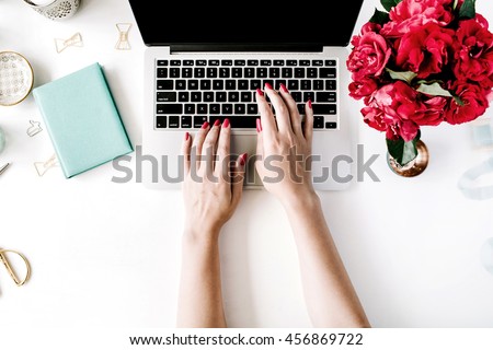 Workplace with laptop, girl's hands, peonies, golden scissors and diary. Flat lay composition for bloggers, magazines, social media and artists. Top view.