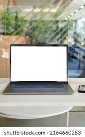 Workplace With Laptop Pc Computer And Cellphone On Desk With Blank White Empty Mockup Screen For Advertising In Modern Contemporary Office. No People. Business Concept. Vertical.