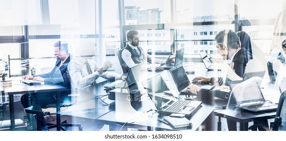 Workplace In Modern Corporate Office With Business People Working On Their Laptops. Window Reflections. Business And Entrepreneurship Concept.